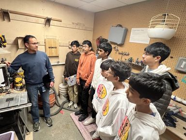 A Microsoft employee showing the team fabrication equipment in a workshop.