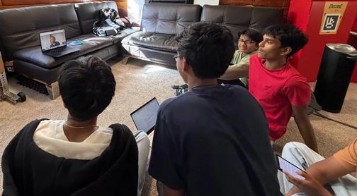 The team gathered around laptops on a video call with a mentor from another FTC team.